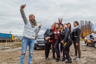 Kızlar arabayla eğitim alanında grup selfie 'si çekerler.