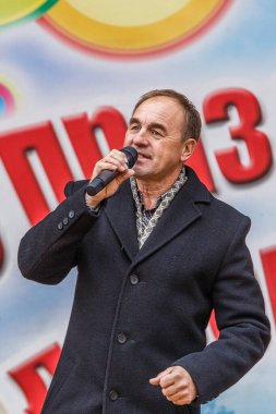 Elinde mikrofon olan adam karaoke söylüyor.