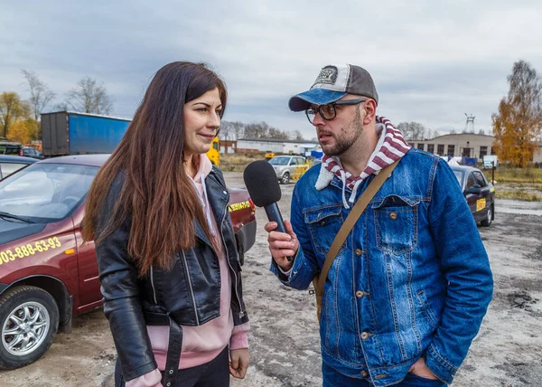 Televizyon gazetecileri, bir sonbahar günü araba yarışındaki kızlarla röportaj yapıyor. — Stok fotoğraf