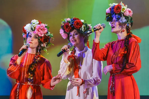 Ragazze in costumi nazionali luminosi cantano sul palco — Foto Stock