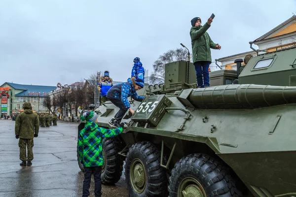 Soldati nella piazza della città in un giorno d'autunno, bambini che giocano con attrezzature militari — Foto Stock