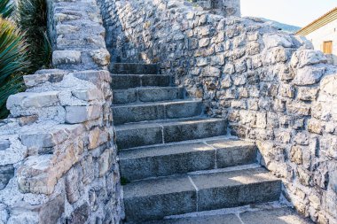 Eski bir kalenin içinde çitleri olan taş bir merdiven..