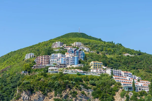 Edificios de hoteles y complejos en una ladera de la montaña en la ciudad de Budva — Foto de Stock