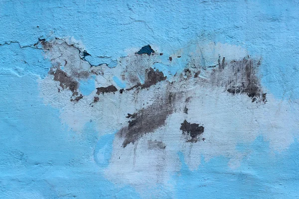 Texture paint old, peeled off pieces from wall, blue background. Concept solar radiation, corrosion.
