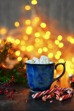 Sıcak kakao ve şekerleme ve şeker köpekler Noel ışıkları arka plan üzerinde seramik kupa
