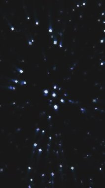 Parlayan parçacıkların büyüleyici bir görüntüsü karanlık bir uzayda dönüyor ve büyüleyici bir atmosfer yaratıyor..