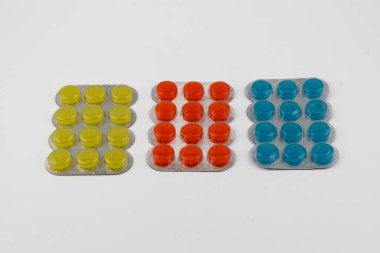 Nötr bir yüzeyde yan yana dizilmiş sarı, turuncu ve mavi tabletlerden oluşan üç su toplayıcı paketi, canlı renklerini ve organize planlarını gözler önüne seriyor..