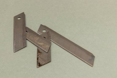 Lviv Ukraine 05.22.25 Several utility blades are displayed in various orientations on a light background, showcasing their sharp edges and distinct shapes for cutting tasks.