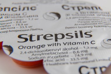 Ukraine Lviv 15.08.25Orange flavored Strepsils with vitamin C are packaged for soothing sore throats. The label includes dosage instructions and ingredients for consumer reference.