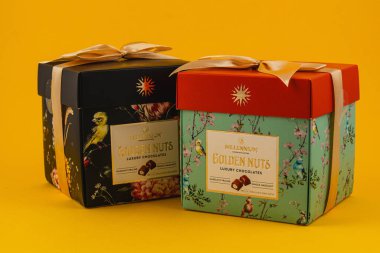 Ukraine Lviv 20.08.25Two beautifully designed luxury chocolate gift boxes are displayed against a vibrant yellow background. Each box has unique floral patterns and a ribbon.