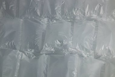 Rows of transparent bubble wrap are arranged neatly, ready for use in protecting fragile items during shipping and storage. The surface is smooth and crinkled.
