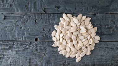 Bir avuç kabak çekirdeği karanlık bir rustik tablo. Vejetaryen mutfağı. Üstten Görünüm.