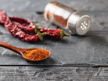 Bir biber kavanoz, üç bakla ve zemin biber rustik bir tabloda bir kaşık. Tüm yemekler için baharat evrensel.