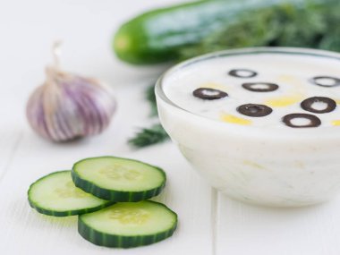 Taze zeytin Beyaz ahşap bir masa üzerinde bir cam kase cacık yaptı. Vejetaryen Yunan mutfağı.