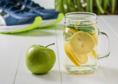 Limon ve nane spor ayakkabı ahşap zemin zemin üzerine yapılmış taze hazırlanmış bir içki. Sağlıklı bir yaşam tarzı kavramı. Spor için şişe.