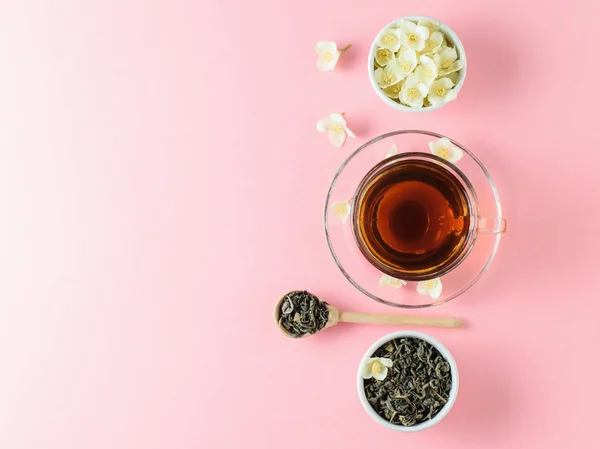 Yasemin ve pembe bir masaya çiçek bir kase bitkisel çay. Sabah kahvaltı bileşimi. Bahar çay kompozisyon beyaz bir tablo. Düz yatıyordu.