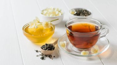 Bir beyaz tahta masaya Yasemin çiçek ile taze hazırlanmış çay. Bahar çay kompozisyon.
