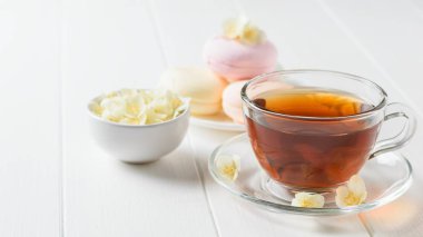 Taze çay ve bir beyaz tahta masada üç renkli şekerleme hazırlanmış. Sabah kahvaltı bileşimi. Bahar çay kompozisyon beyaz bir tablo.