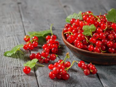 Rustik bir tabloda bir kil kase taze çekilmiş somun çilek. Sağlıklı doğal gıda kavramı.