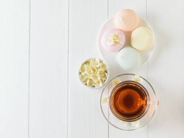 Yasemin ve beyaz bir masaya çiçek bir kase bitkisel çay. Sabah kahvaltı bileşimi. Bahar çay kompozisyon beyaz bir tablo. Düz yatıyordu.