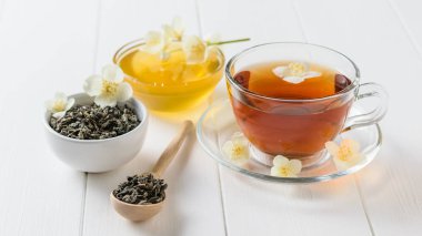 Bir beyaz tahta masaya Yasemin çiçek ile taze hazırlanmış çay. Bahar çay kompozisyon.