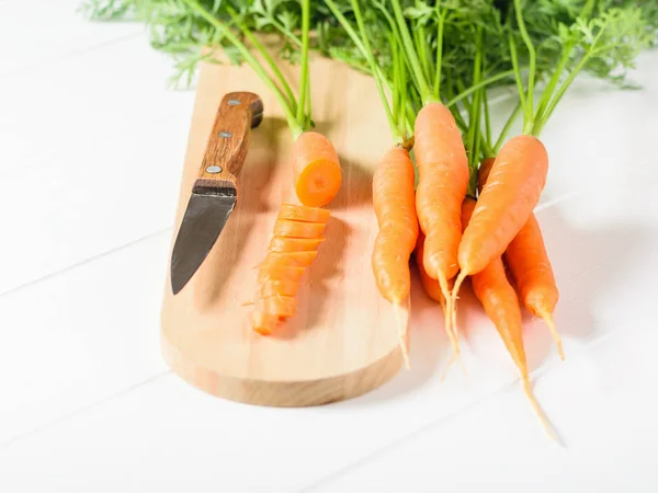 Нарезанная Морковь Ножом Разделочной Доске Куча Моркови Белом Столе Концепция — стоковое фото
