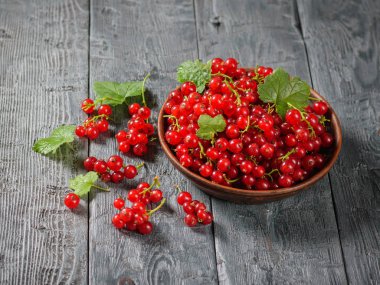 Rustik bir tabloda bir kil kase taze çekilmiş somun çilek. Sağlıklı doğal gıda kavramı.