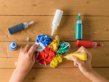 Kız bir t-shirt kravat boya tarzında bir sarı renk koyar. Kravat boya tarzı kumaş boyama.