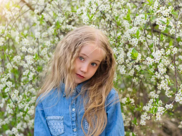 桜の園でダウン彼女の髪とシャツにデニム女の子の美しい肖像画 笑って幸せな少女の肖像画 — ストック写真