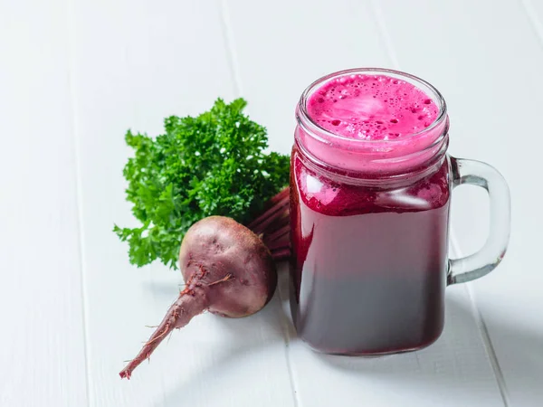 Beyaz ahşap bir masa üzerine maydanoz ve Pancar taze yapılmış smoothies ile kupa. Beslenme kilo kaybı için. Doğal gıda kavramı.