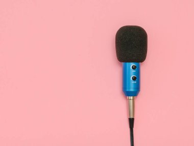 Mavi mikrofon tel üzerinde pembe bir arka plan ile. Minimalizm. Üstten görünüm. Müzik Stüdyo donatımı. Düz yatıyordu.