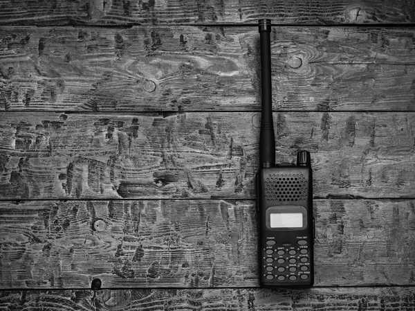Black and white image of a walkie-talkie on a wooden table. Wireless communication facility of the past.