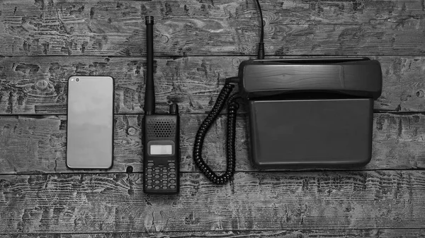 Black and white image of a walkie-talkie on a wooden table. Wireless communication facility of the past.
