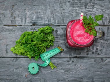 Taze pancar güler yüzlü, iki pancar ve maydanoz siyah ahşap masa üzerinde. Diyet doğal gıda kavramı. Beslenme kilo kaybı için. Üstten görünüm. Düz yatıyordu.