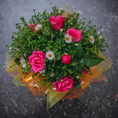 Güzel buket kırmızı ve beyaz siyah bir taş tabloda yeşil bitkiler ile. Farklı renklerde güzel bileşimi. Üstten görünüm. Düz yatıyordu.