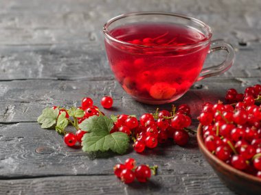 Frenk üzümü serinletici bir içki ve bir kase taze çilek ile cam kupa. Doğal içki yenileniyor. Sağlıklı doğal gıda kavramı.