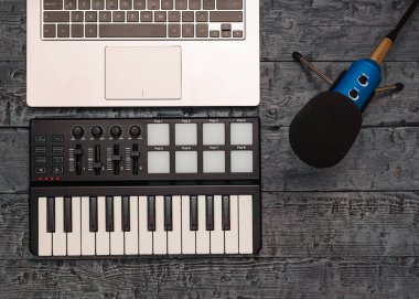 Elektronik müzik karıştırıcı ve siyah ahşap bir masa üzerindeki tel mikrofon. Müzik Stüdyo donatımı. Üstten görünüm. Düz yatıyordu.