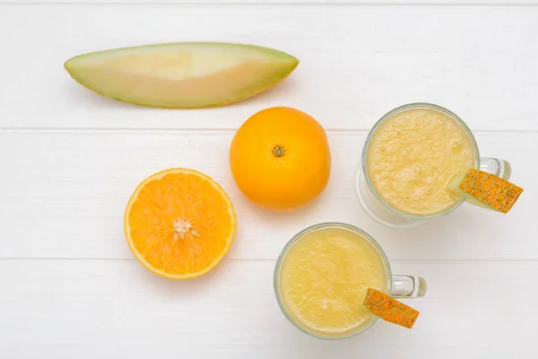 Two Melon Smoothie Cups Cut Orange Piece Melon White Table — Stock Photo, Image