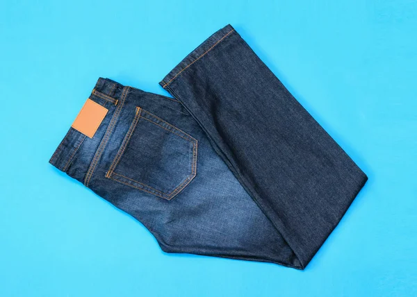 Zusammengefaltet Einer Halben Männer Blue Jeans Auf Blauem Hintergrund Die — Stockfoto