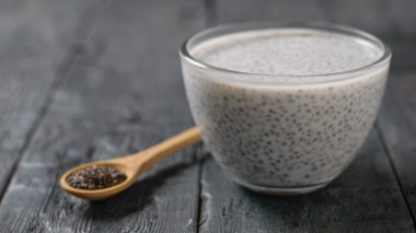 Cam kase sütlü Chia tohum puding koyu ahşap masa üzerinde. Diyet gıda kilo kaybı ve vücut temizliği için.