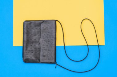 Sarı ve mavi zemin üzerine mavi deri çanta güzel kadınlar. Bayan aksesuarlar renkli arka plan üzerinde. Üstten görünüm. Düz yatıyordu.