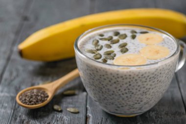 Chia tohum puding muz ve kabak tohumu koyu ahşap bir masa üzerinde. Diyet gıda kilo kaybı ve vücut temizliği için.