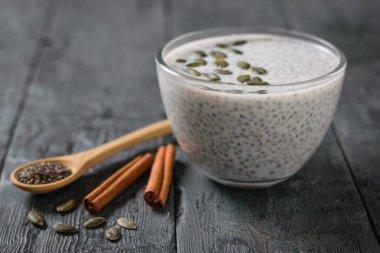 Chia tohum koyu ahşap bir masa üzerinde süt, tarçın ve balkabağı tohumları ile. Diyet gıda kilo kaybı ve vücut temizliği için.