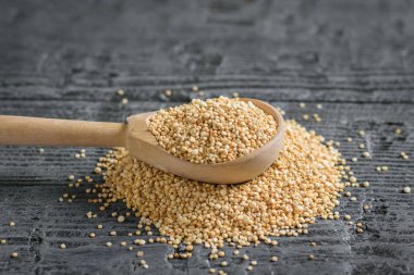 Solmayan çiçek tohumu ve koyu ahşap bir masa üzerinde bir tahta kaşık yığını. Gluten free gıda. Üstten görünüm. Düz yatıyordu.