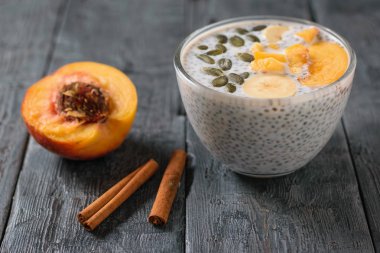 Chia tohum puding ve koyu ahşap bir masa üzerinde iki tarçın bir cam kase. Diyet gıda kilo kaybı ve vücut temizliği için.