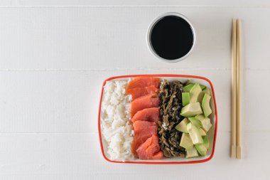 Hawaii pirinç, avokado, somon ve yosun ve soya sosu bir tabak. Akdeniz diyeti mutfağı. Üstten görünüm. Düz yatıyordu.