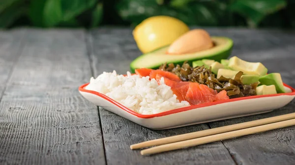 Hawaii pirinç, avokado, somon ve yosun ve soya sosu bir tabak. Akdeniz diyeti mutfağı.