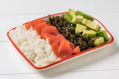 Pirinç, avokado, somon ve beyaz ahşap rustik masa üzerinde varek kase. Akdeniz diyeti mutfağı