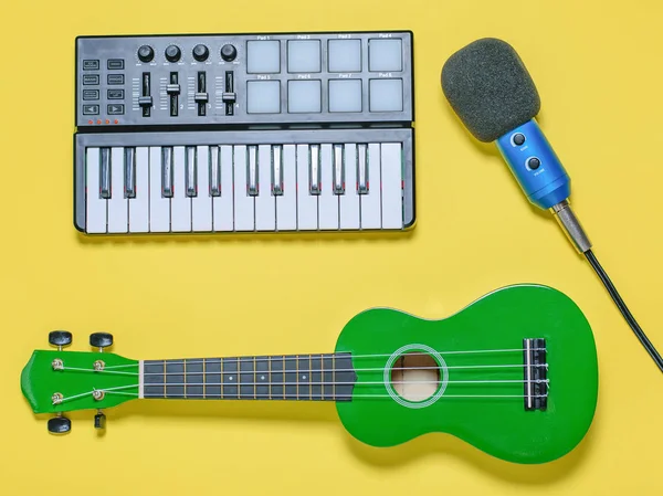 绿色四弦琴 蓝色麦克风与电线和音乐混音器在黄色背景 录制音乐曲目的设备 从顶部的视图 — 图库照片
