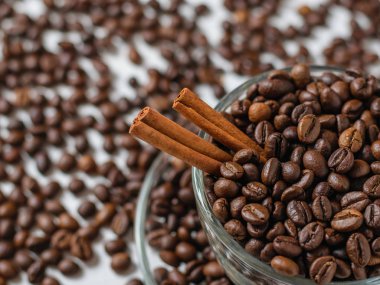 Beyaz ahşap bir masa üzerinde kahve çekirdekleri ile kahve fincanı cam. Taneleri popüler içki hazırlanması için.